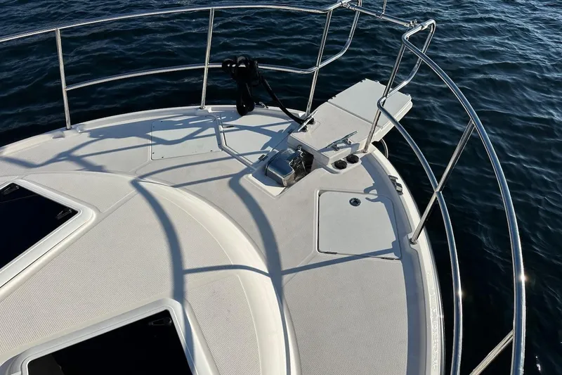 Buoy Boys Yacht Photos Pics Bow of 2025 Ranger Tugs R-29 CB boat with railing and anchor, on water.