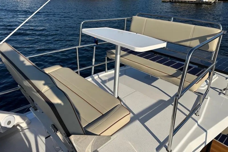 Buoy Boys Yacht Photos Pics 2025 Ranger Tugs R-29 CB boat deck with seating and table, overlooking water.