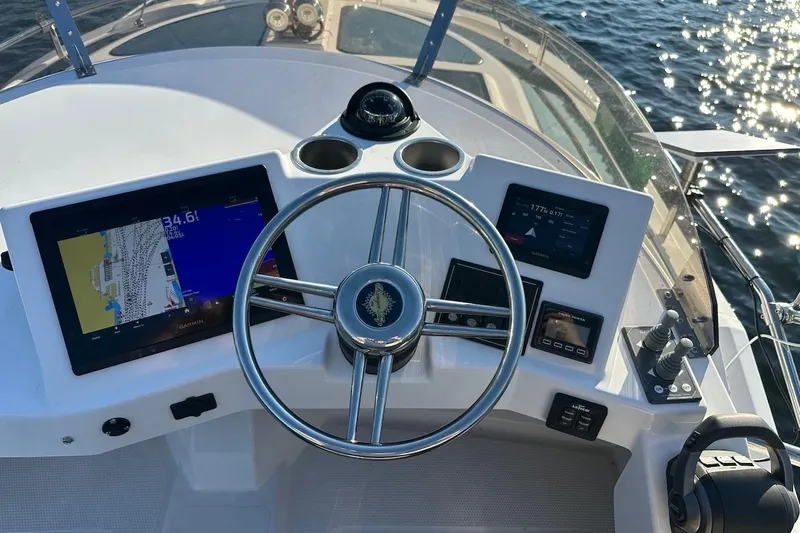 Buoy Boys Yacht Photos Pics 2025 Ranger Tugs R-29 CB helm with navigation screens and steering wheel on open water.