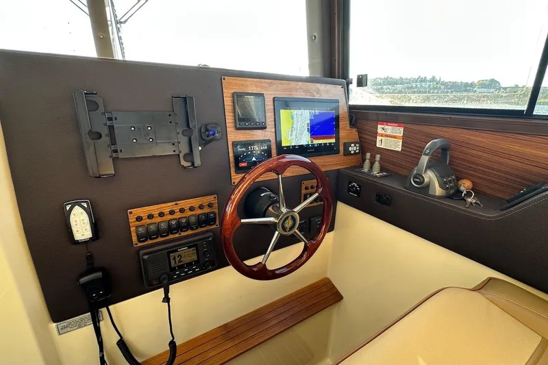 Buoy Boys Yacht Photos Pics 2025 Ranger Tugs R-29 CB helm with navigation controls and wooden steering wheel.