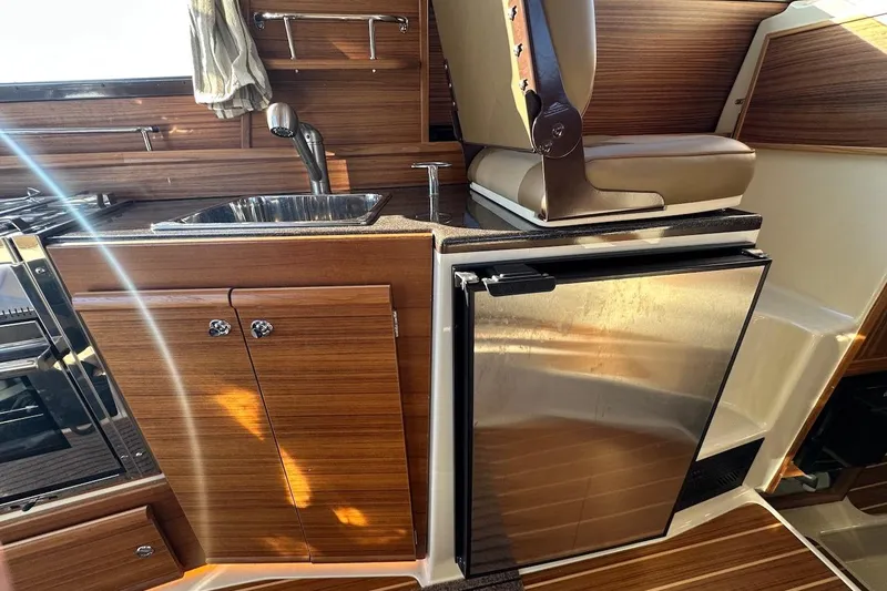Buoy Boys Yacht Photos Pics 2025 Ranger Tugs R-29 CB interior with wood finish, sink, and stainless steel fridge.