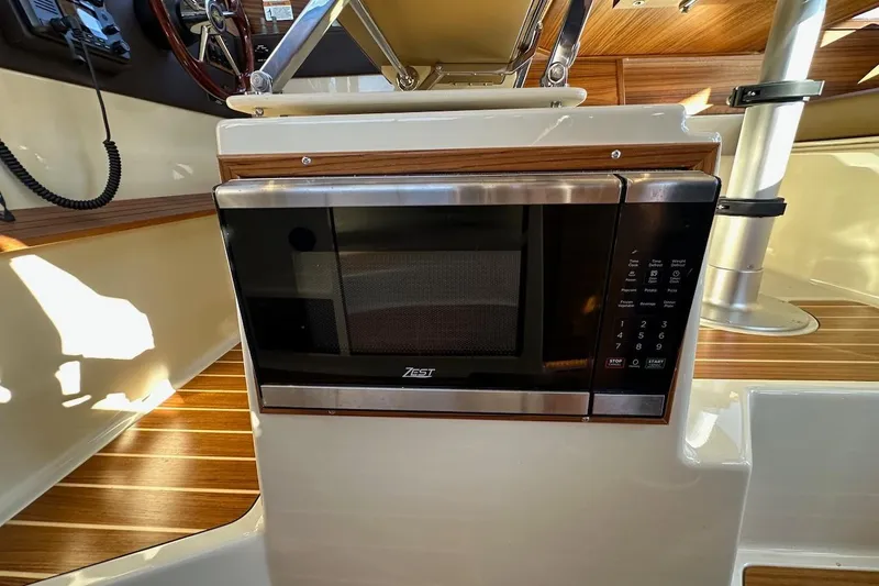 Buoy Boys Yacht Photos Pics 2025 Ranger Tugs R-29 CB interior with built-in Zest microwave, wood accents, and steering wheel.