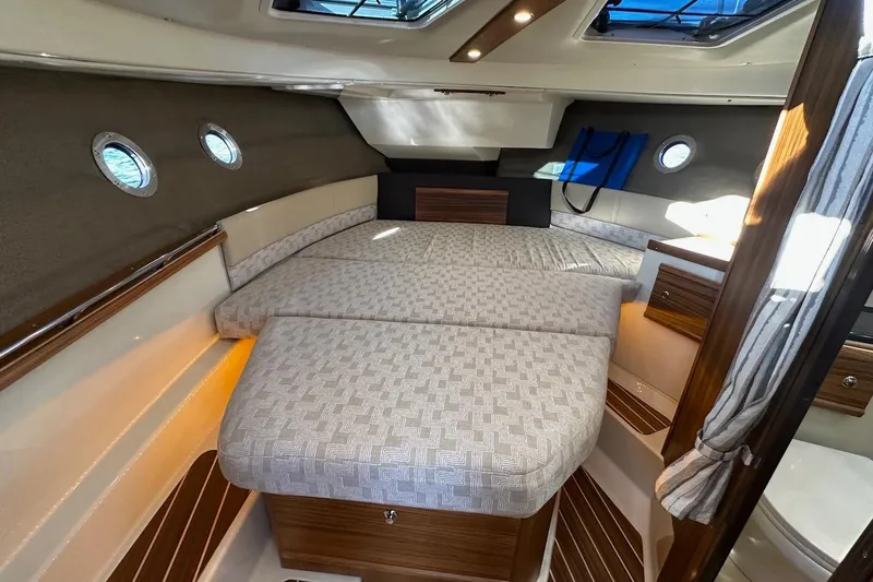 Buoy Boys Yacht Photos Pics 2025 Ranger Tugs R-29 CB interior cabin with cozy bed and elegant wood finishes.