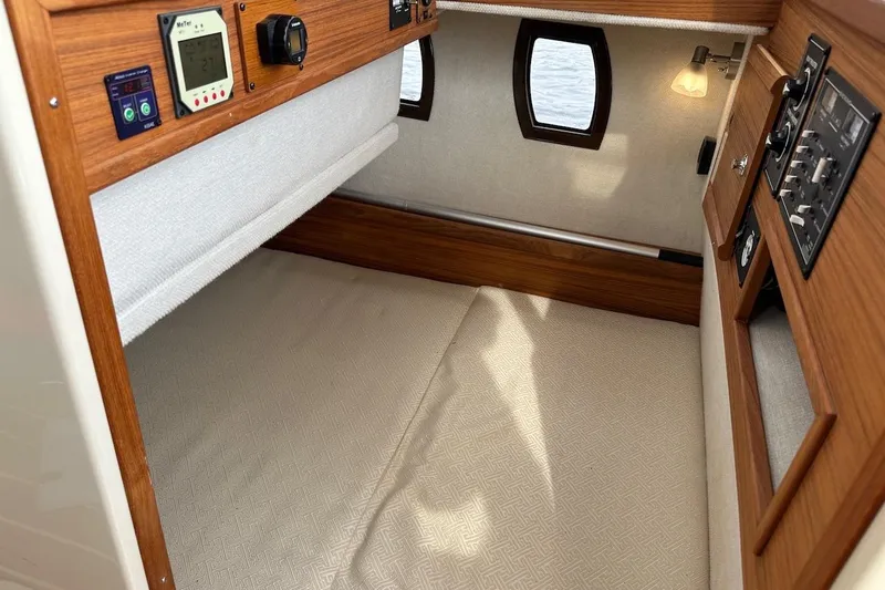 Buoy Boys Yacht Photos Pics 2025 Ranger Tugs R-29 CB cabin interior with wood paneling and control panels.
