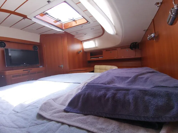  Yacht Photos Pics Luxurious cabin interior of a 2004 Hallberg-Rassy 62 yacht with cozy bedding and wooden finishes.