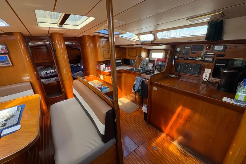 Skye Yacht Photos Pics Interior of a 1990 Beneteau Oceanis 500 sailboat with wood finish and cozy seating.