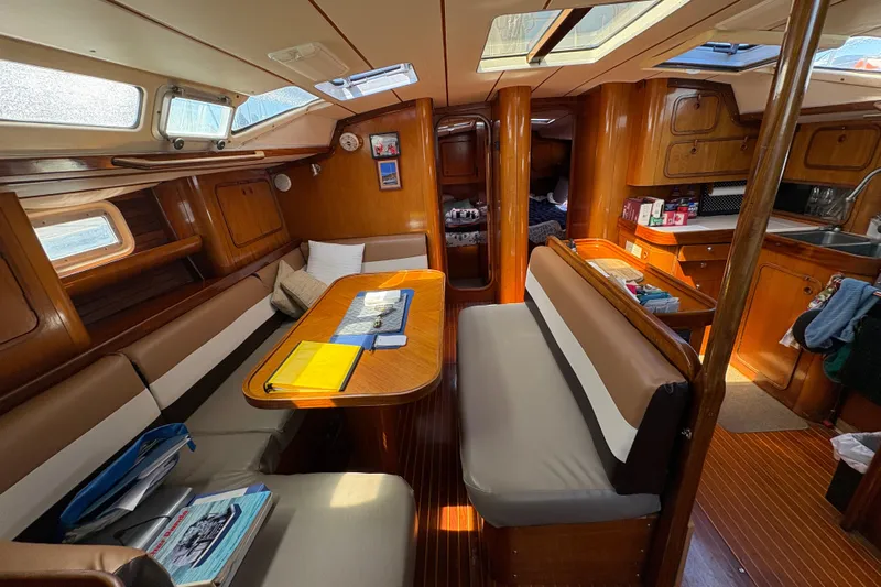 Skye Yacht Photos Pics Interior of 1990 Beneteau Oceanis 500 sailboat, featuring cozy seating and wooden cabinetry.