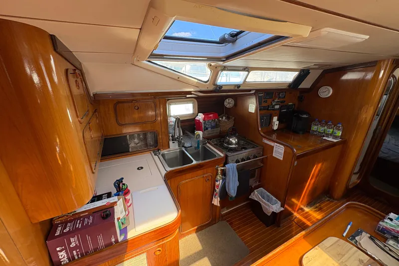 Skye Yacht Photos Pics Interior of 1990 Beneteau Oceanis 500 yacht kitchen with wooden cabinetry and skylight.
