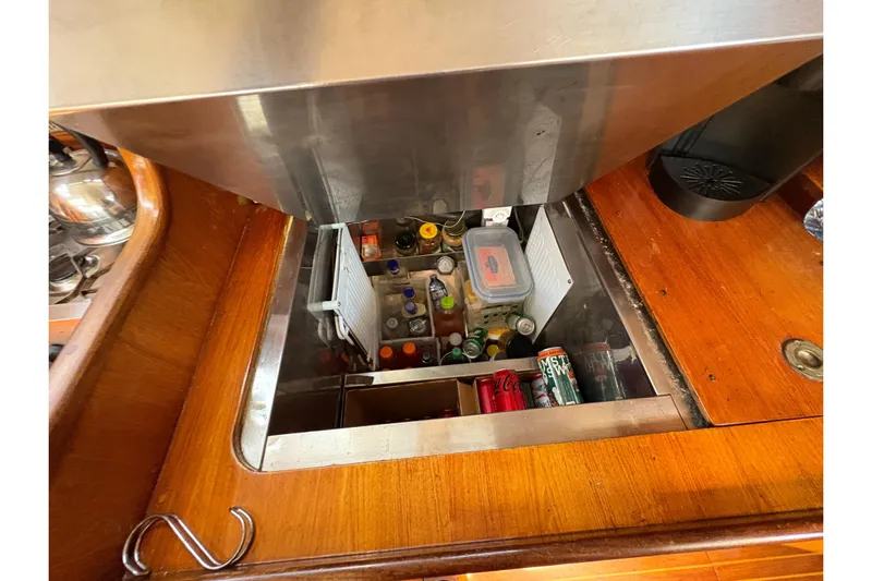 Skye Yacht Photos Pics Interior view of Beneteau Oceanis 500 yacht's kitchen storage, featuring beverages and containers.