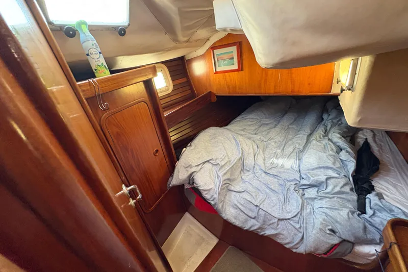 Skye Yacht Photos Pics Cozy cabin interior of 1990 Beneteau Oceanis 500 sailboat with wooden finish and bed.