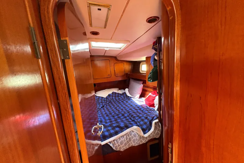 Skye Yacht Photos Pics Cozy cabin interior of 1990 Beneteau Oceanis 500 sailboat with wooden finish and bed.