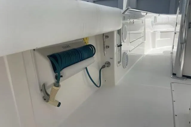 T/t Aloan At Last Yacht Photos Pics 2015 Edgewater 318CC boat interior with coiled hose and storage compartments.
