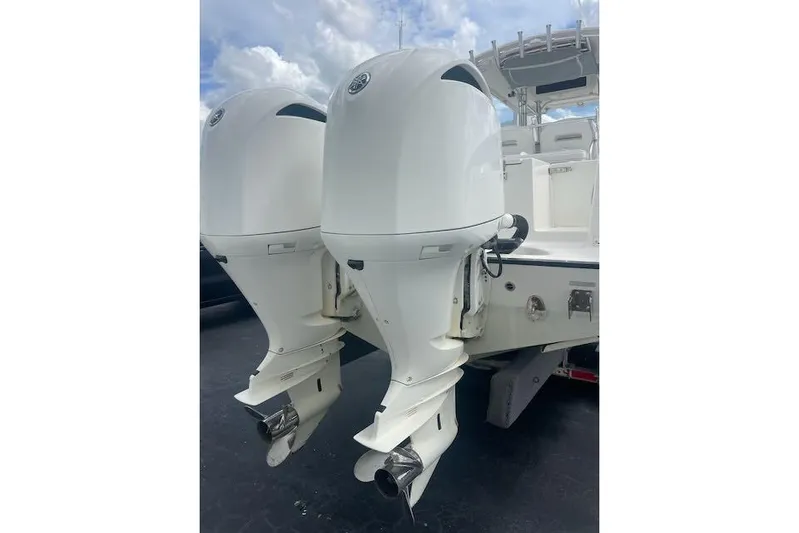 T/t Aloan At Last Yacht Photos Pics Twin outboard engines on a 2015 Edgewater 318CC boat under a cloudy sky.