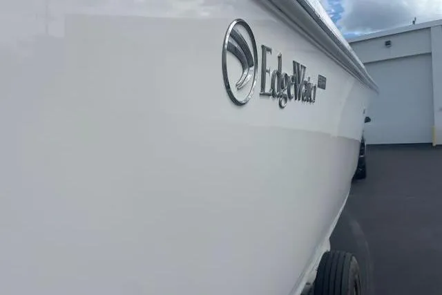 T/t Aloan At Last Yacht Photos Pics 2015 Edgewater 318CC boat side view with logo, parked outdoors.