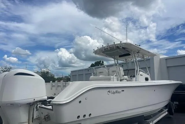 T/t Aloan At Last Yacht Photos Pics 2015 Edgewater 318CC boat with dual engines, parked outdoors under a cloudy sky.