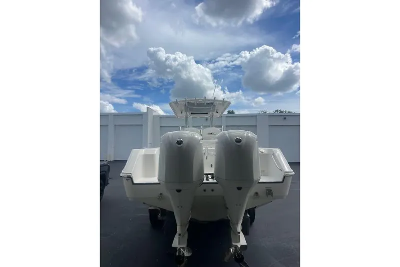 T/t Aloan At Last Yacht Photos Pics 2015 Edgewater 318CC boat with dual outboard motors under a cloudy sky.