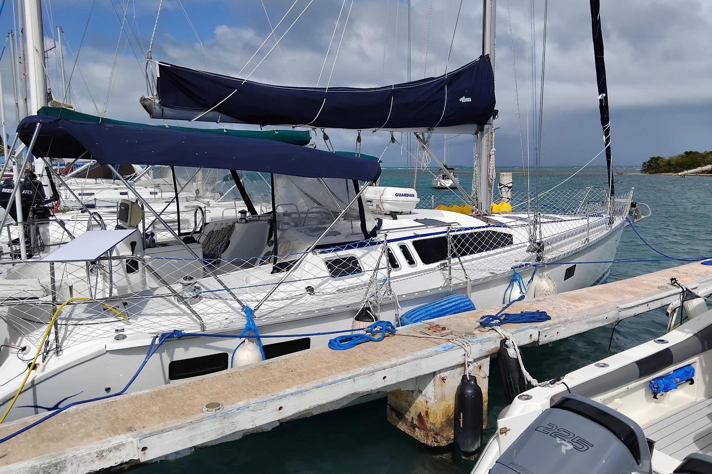 Sailboat Hunter Legend 40.5, 1994 model, docked at marina with blue covers.