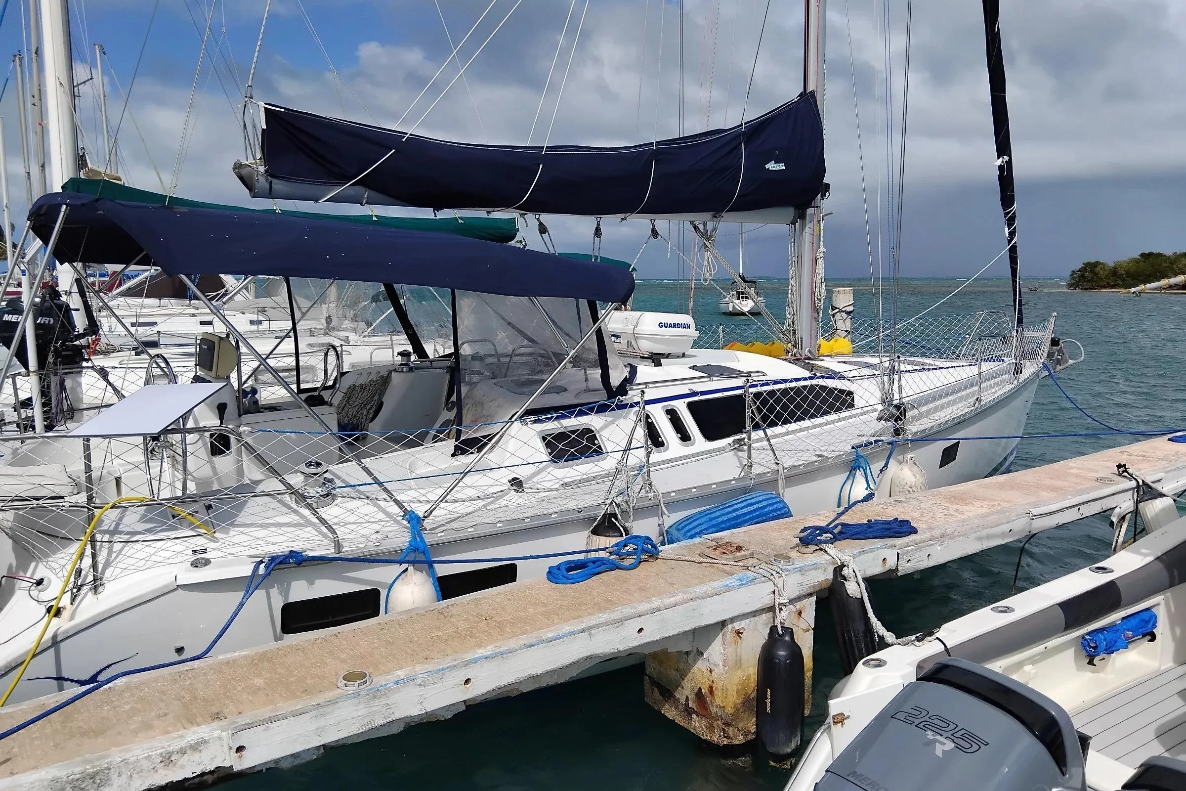 Sailboat Hunter Legend 40.5, 1994 model, docked at marina with blue covers.