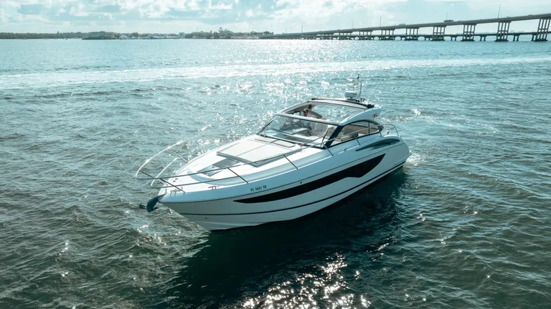 Angeliki Yacht Photos Pics 2021 Princess V40 yacht cruising on open water near a bridge.