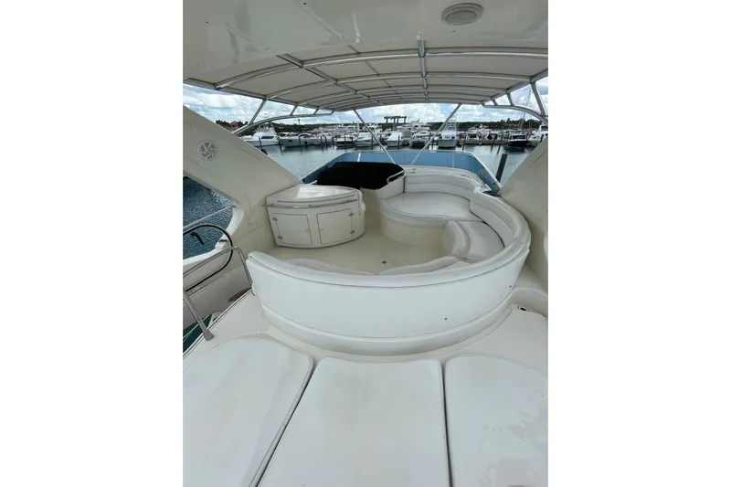  Yacht Photos Pics 2005 Azimut 55 Flybridge yacht with spacious white seating area and marina view.
