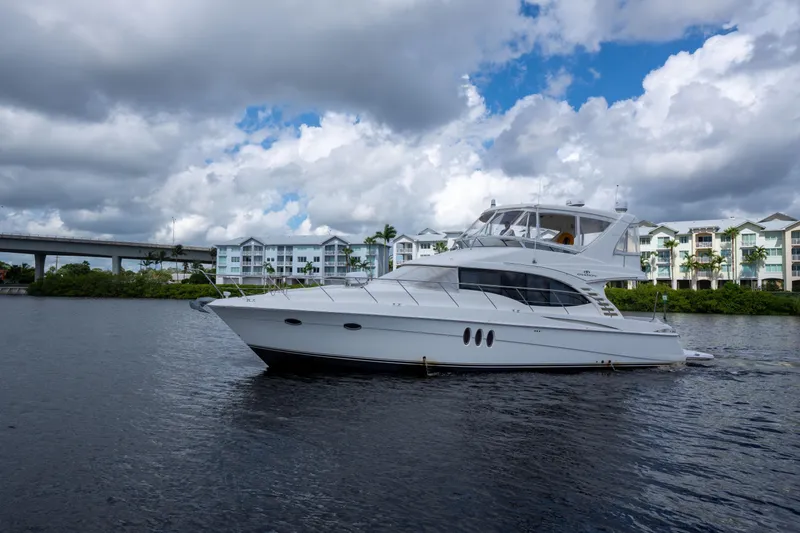 Immersed Yacht Photos Pics 2009 Silverton Oviation 52 yacht on water, cloudy sky, waterfront buildings in background.