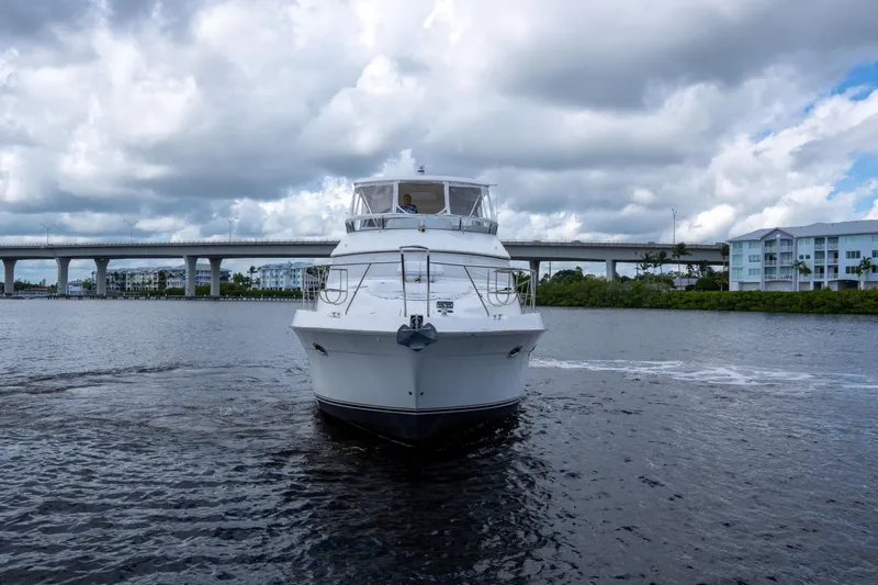 Immersed Yacht Photos Pics 2009 Silverton Oviation 52 yacht cruising under cloudy skies near a bridge.