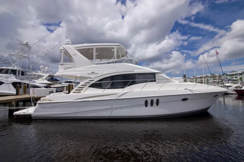 Immersed Yacht Photos Pics 2009 Silverton Oviation 52 yacht docked at marina under cloudy sky.