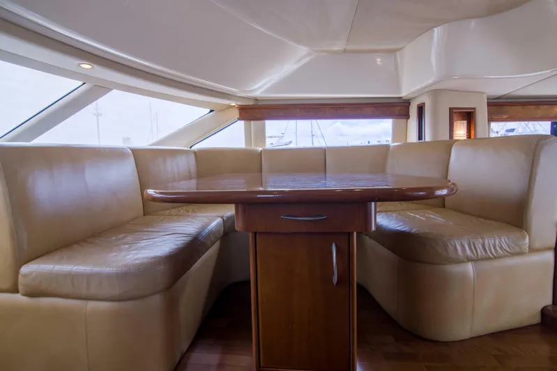 Immersed Yacht Photos Pics Luxurious interior of 2009 Silverton Oviation 52 yacht with leather seating and wooden table.