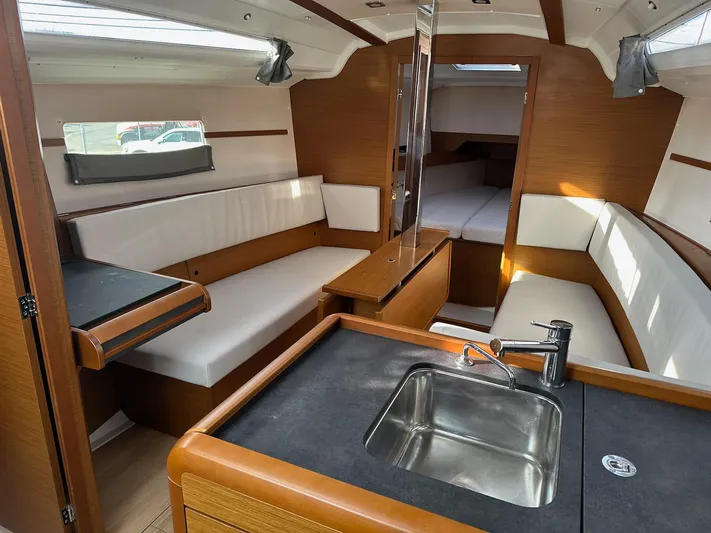  Yacht Photos Pics Interior of 2020 Jeanneau Sun Odyssey 349 sailboat, featuring modern seating and kitchenette.
