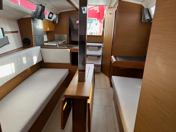  Yacht Photos Pics Interior of 2020 Jeanneau Sun Odyssey 349 sailboat, featuring modern wood finish and seating.