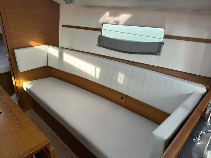  Yacht Photos Pics Interior of 2020 Jeanneau Sun Odyssey 349 sailboat with white cushioned seating.