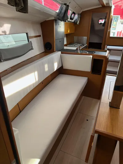 Yacht Photos Pics Interior of 2020 Jeanneau Sun Odyssey 349 sailboat, featuring modern seating and compact kitchen area.