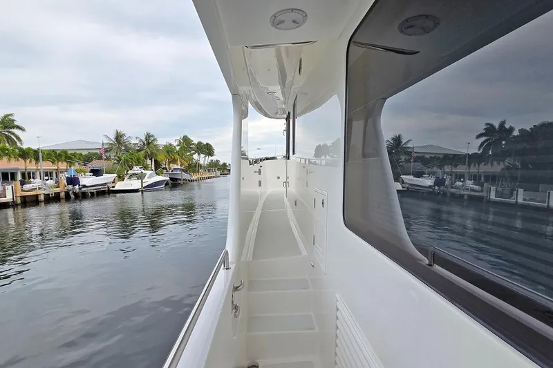 Suertudo Yacht Photos Pics 2020 Outer Reef Yachts 720 Motoryacht docked, showcasing sleek side deck and waterfront view.