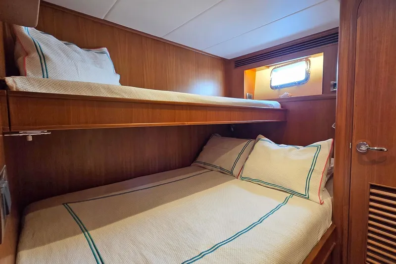 Suertudo Yacht Photos Pics 2020 Outer Reef Yachts 720 Motoryacht cabin with wooden bunk beds and window.