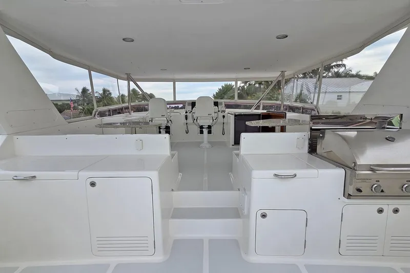 Suertudo Yacht Photos Pics 2020 Outer Reef Yachts 720 Motoryacht flybridge with seating and grill, showcasing luxury design.