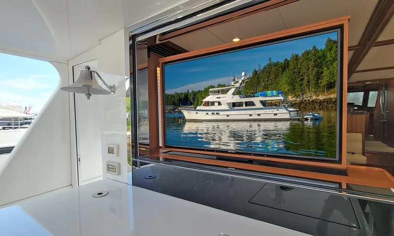 Suertudo Yacht Photos Pics 2020 Outer Reef Yachts 720 Motoryacht on serene water, viewed through a yacht window.