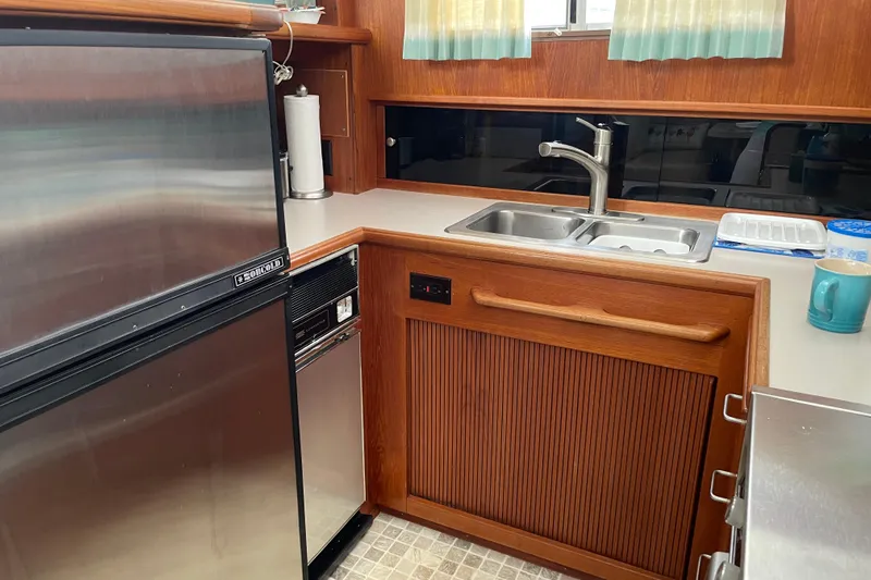  Yacht Photos Pics 1988 Tollycraft 40 Sundeck Motor Yacht kitchen with stainless steel appliances and wooden cabinetry.