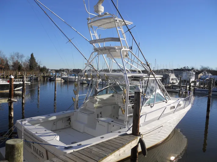 Fish Tales Yacht Photos Pics Boston Whaler 34 Defiance 2000 docked in a marina under clear blue skies.
