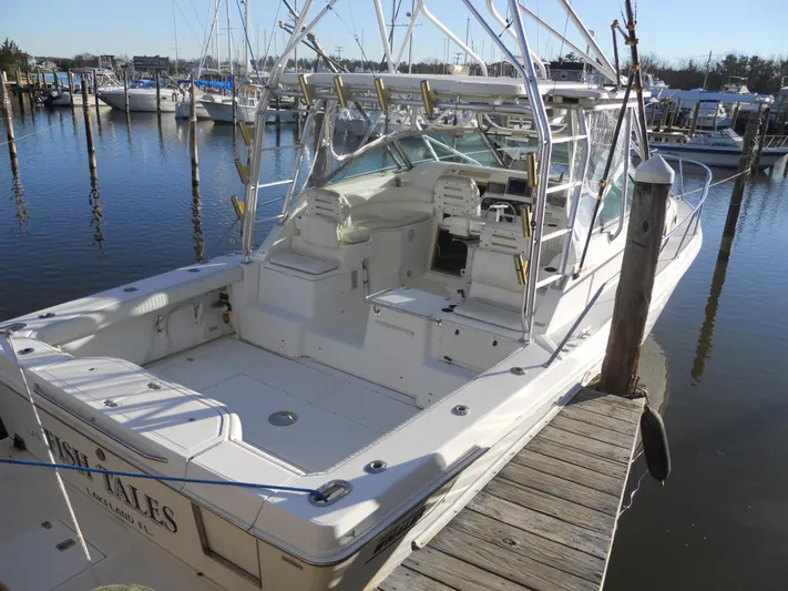 Fish Tales Yacht Photos Pics 2000 Boston Whaler 34 Defiance boat docked at marina, featuring spacious deck and seating.