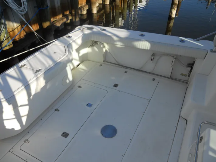 Fish Tales Yacht Photos Pics Boston Whaler 34 Defiance 2000 boat deck, spacious and clean, docked by wooden pilings.