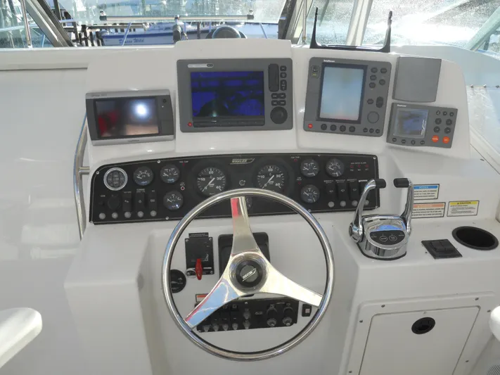 Fish Tales Yacht Photos Pics Control panel of a 2000 Boston Whaler 34 Defiance boat with steering wheel and navigation instruments.