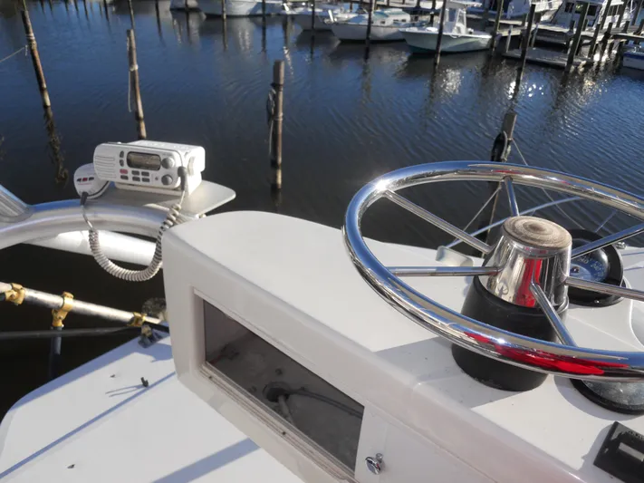 Fish Tales Yacht Photos Pics Boston Whaler 34 Defiance 2000 boat helm with steering wheel and radio, docked at marina.
