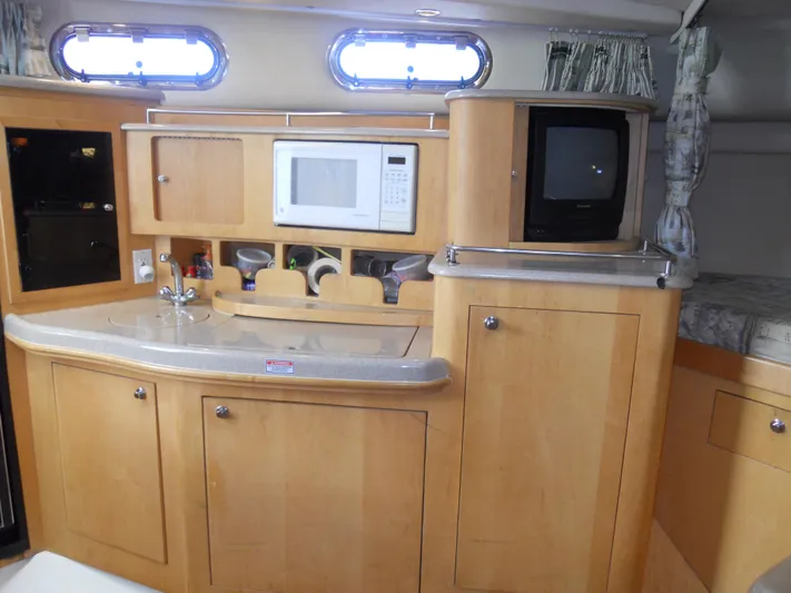 Fish Tales Yacht Photos Pics Interior of 2000 Boston Whaler 34 Defiance with kitchenette and TV.