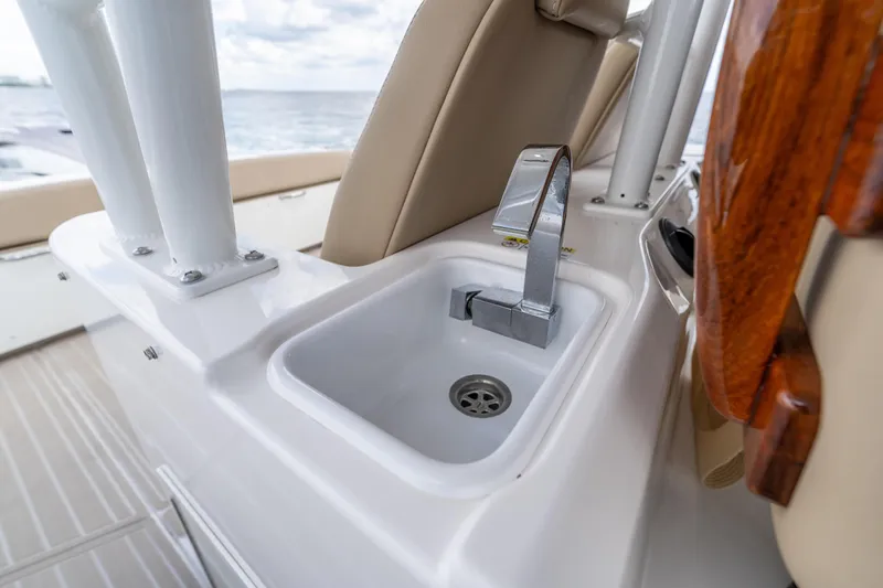 Golden Hour Yacht Photos Pics Everglades 395 Center Console 2021 boat sink with modern faucet, ocean in background.