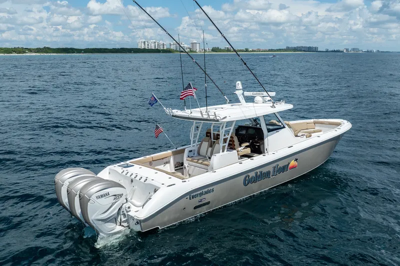 Golden Hour Yacht Photos Pics 2021 Everglades 395 Center Console boat cruising on open water with fishing rods.