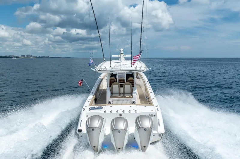 Golden Hour Yacht Photos Pics 2021 Everglades 395 Center Console boat cruising on open water, rear view.