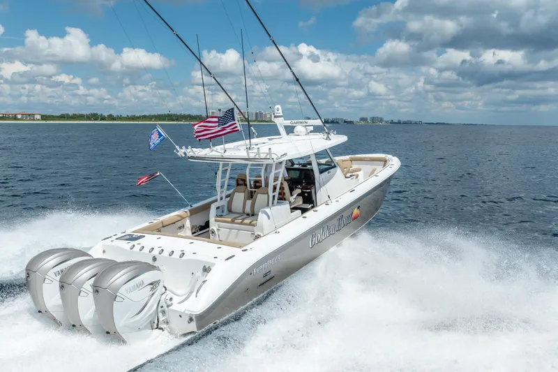 Golden Hour Yacht Photos Pics 2021 Everglades 395 Center Console boat cruising on open water with triple Yamaha engines.