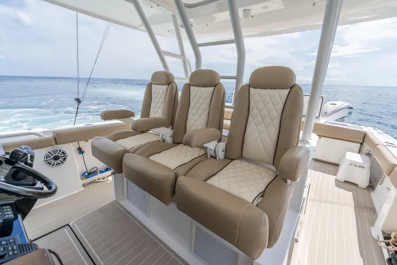 Golden Hour Yacht Photos Pics Luxurious seating on 2021 Everglades 395 Center Console boat, ocean view in background.