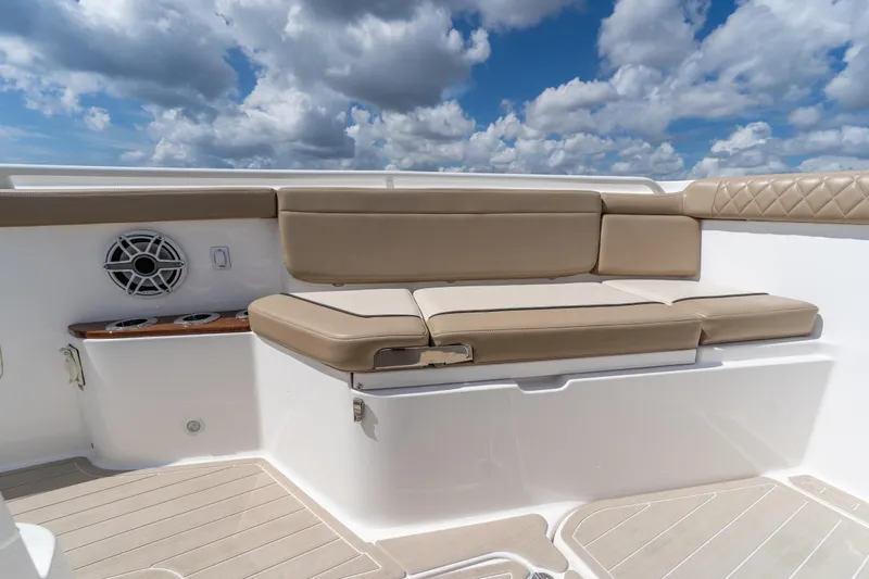 Golden Hour Yacht Photos Pics 2021 Everglades 395 Center Console boat seating with beige cushions under a cloudy sky.