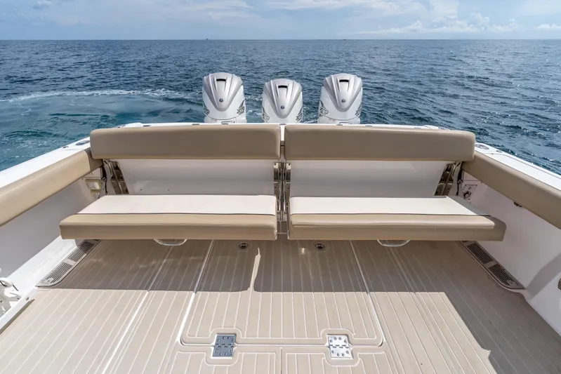 Golden Hour Yacht Photos Pics 2021 Everglades 395 Center Console boat with triple engines, beige seating, and ocean backdrop.